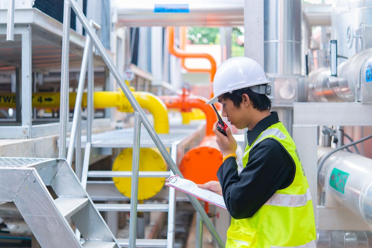 Asian Maintenance engineer at the waste water management system of a huge factory,maintenance checking technical data of heating system equipment,Thailand people